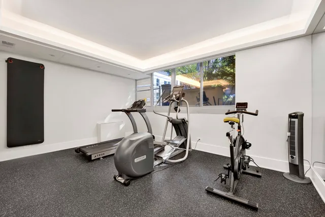 a room with gym equipment and view of living room