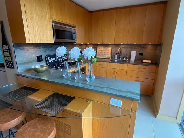 a kitchen with stainless steel appliances granite countertop a stove a sink and a microwave
