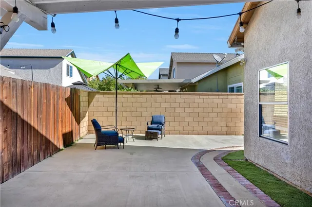 a view of a patio with table and chairs with wooden floor and fence