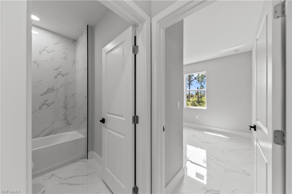 237 Columbus Boulevard South Lehigh Acres, FL 33974 - Photo 20 of 25 a bathroom with a bathtub and shower