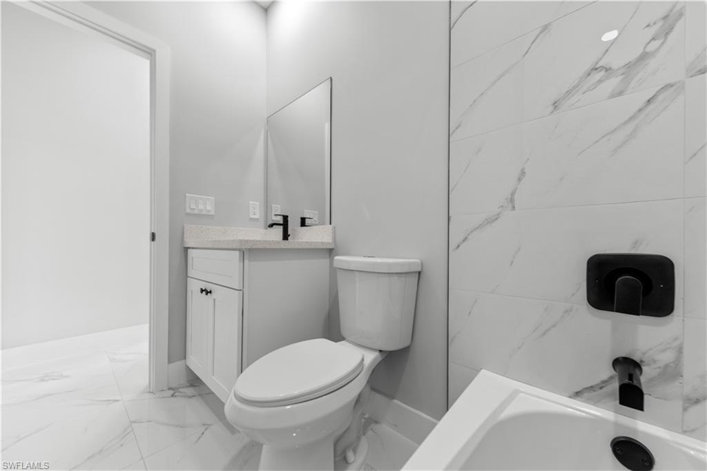 237 Columbus Boulevard South Lehigh Acres, FL 33974 - Photo 21 of 25 a bathroom with a sink a toilet and mirror