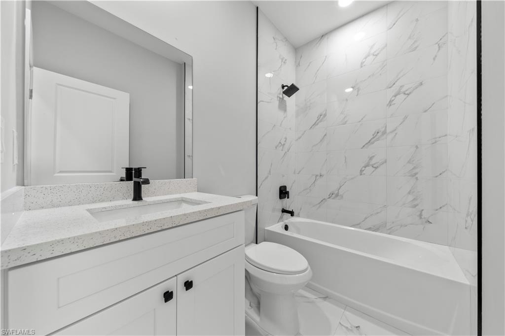 237 Columbus Boulevard South Lehigh Acres, FL 33974 - Photo 22 of 25 a bathroom with a sink a toilet and a bathtub