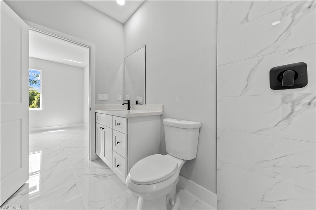 237 Columbus Boulevard South Lehigh Acres, FL 33974 - Photo 23 of 25 a bathroom with a toilet sink and mirror