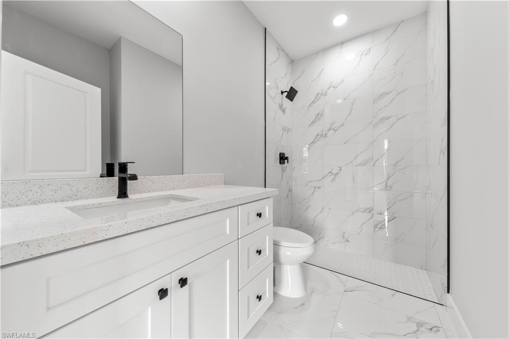 237 Columbus Boulevard South Lehigh Acres, FL 33974 - Photo 24 of 25 a bathroom with a granite countertop sink a toilet and shower