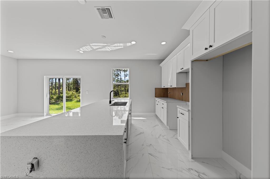 237 Columbus Boulevard South Lehigh Acres, FL 33974 - Photo 3 of 25 a kitchen with white cabinets and window