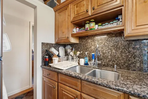 a kitchen with stainless steel appliances granite countertop a sink and a stove