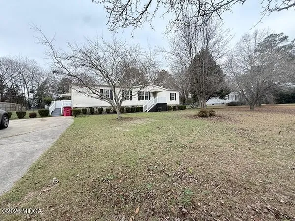 a view of a white house with a yard covered in snow