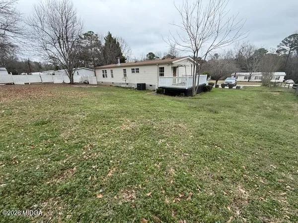 a view of a house with a big yard and large trees