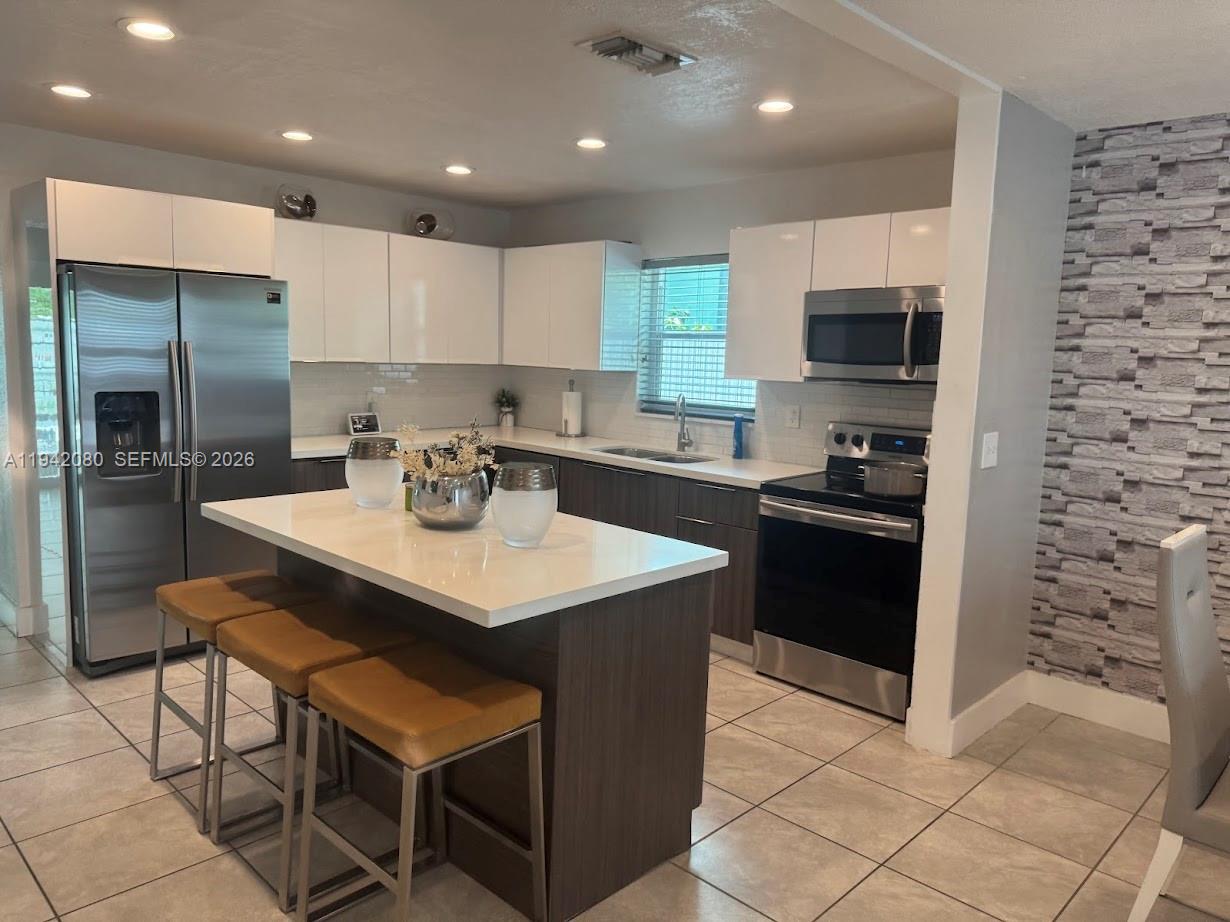 412 West 15th Street Hialeah, FL 33010 - Photo 14 of 48 a kitchen with a sink cabinets and stainless steel appliances