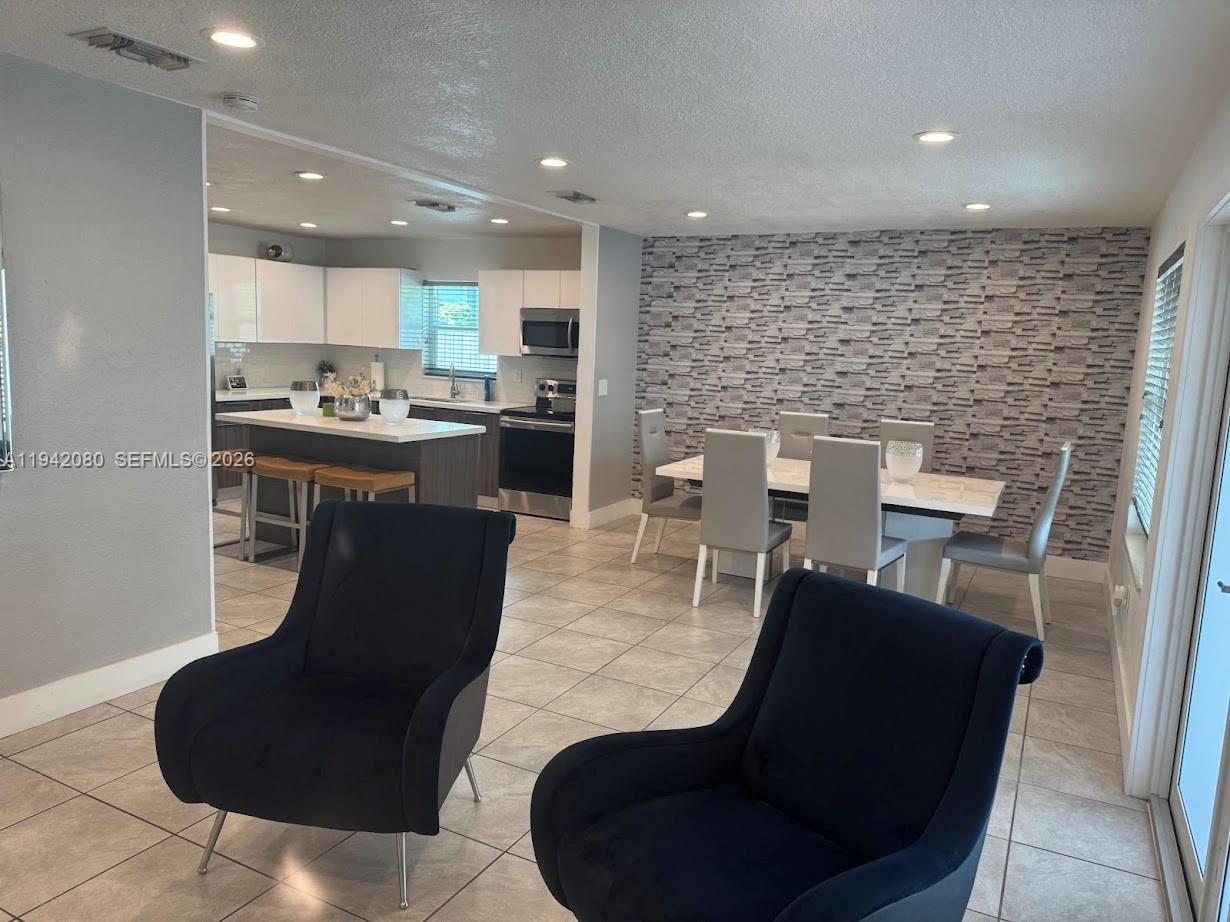 412 West 15th Street Hialeah, FL 33010 - Photo 14 of 49 a kitchen with a table chairs and a microwave