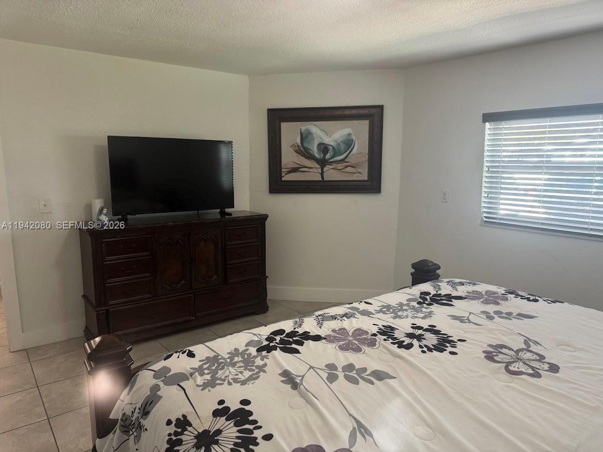 412 West 15th Street Hialeah, FL 33010 - Photo 17 of 49 a bedroom with a bed and a flat screen tv