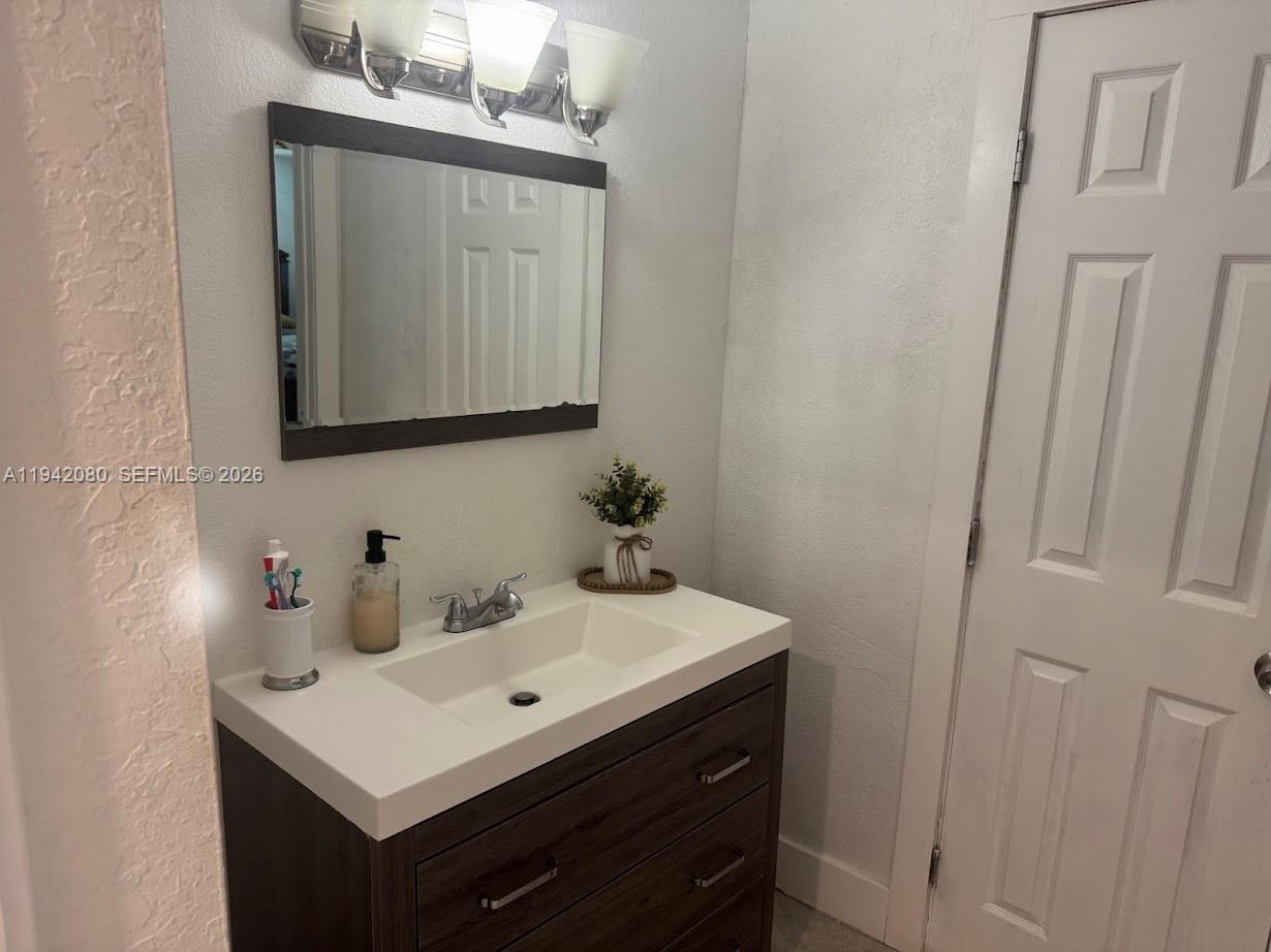 412 West 15th Street Hialeah, FL 33010 - Photo 18 of 48 a bathroom with a sink a vanity and a mirror