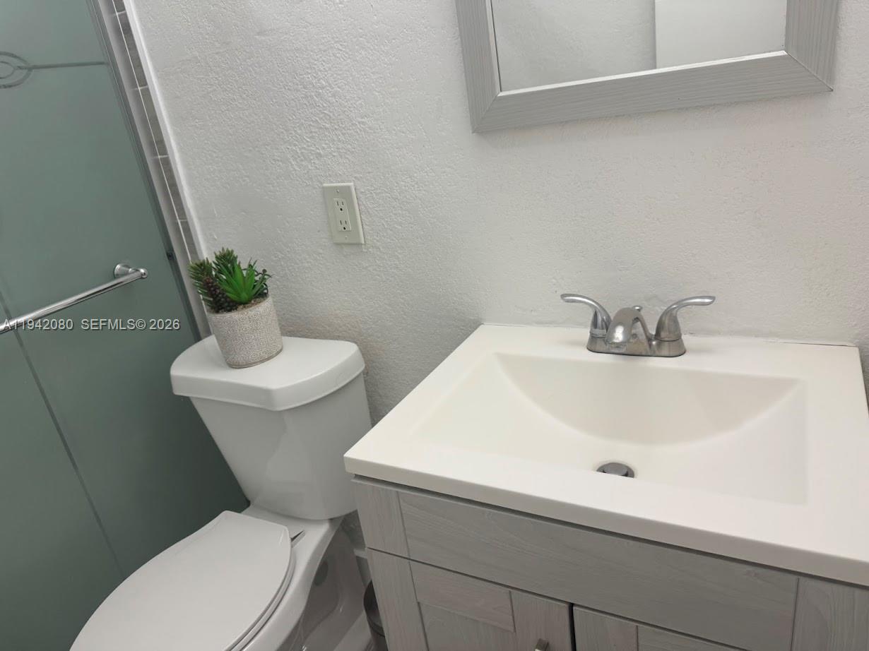 412 West 15th Street Hialeah, FL 33010 - Photo 22 of 48 a bathroom with a sink a toilet and a mirror