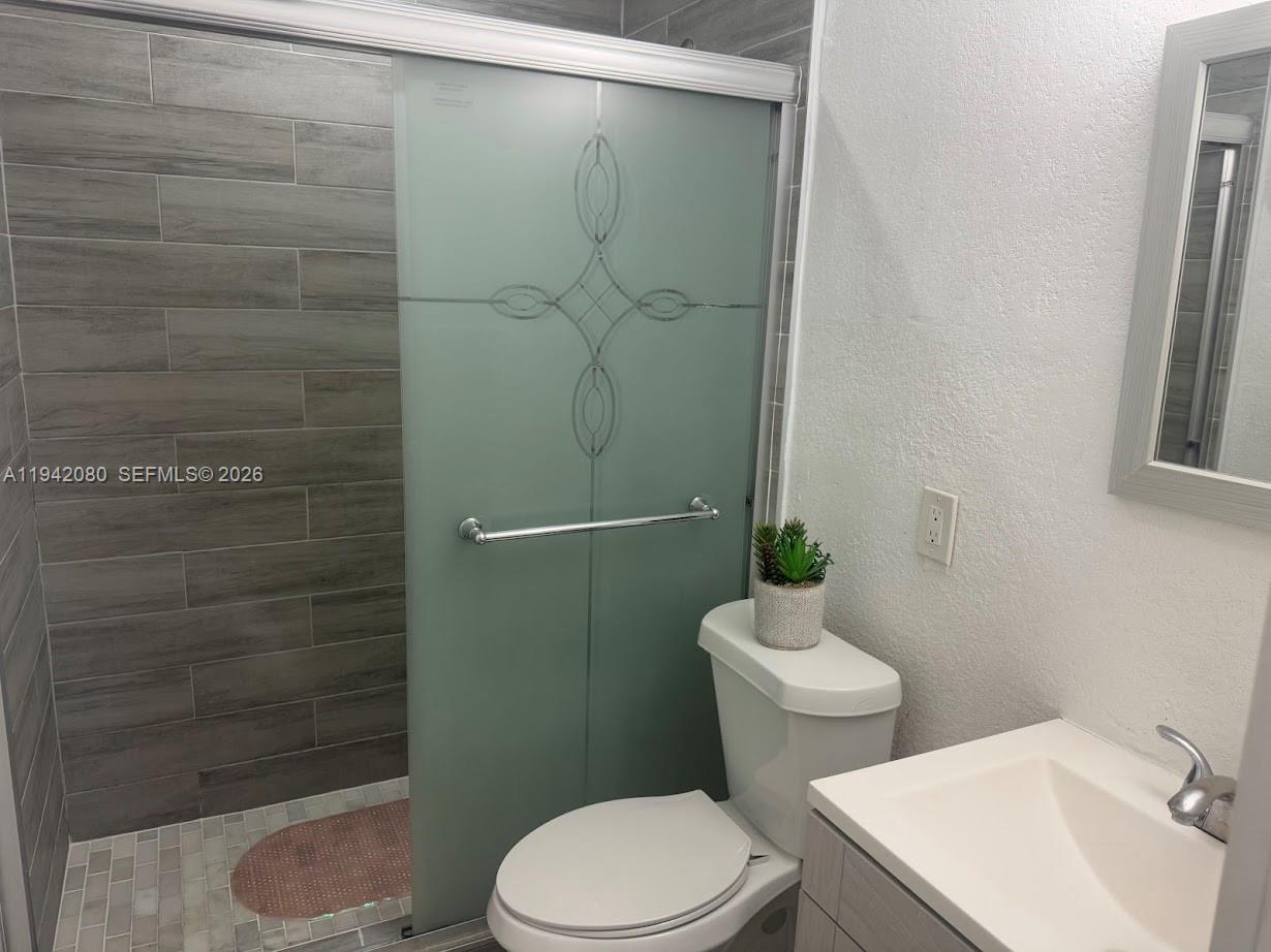 412 West 15th Street Hialeah, FL 33010 - Photo 25 of 49 a white toilet sitting next to a bathroom sink and a shower