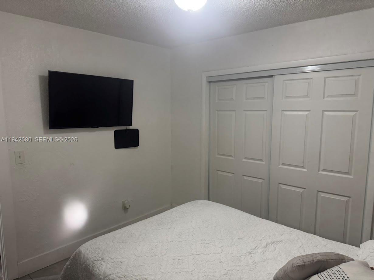 412 West 15th Street Hialeah, FL 33010 - Photo 28 of 49 a bedroom with a bed and a flat screen tv