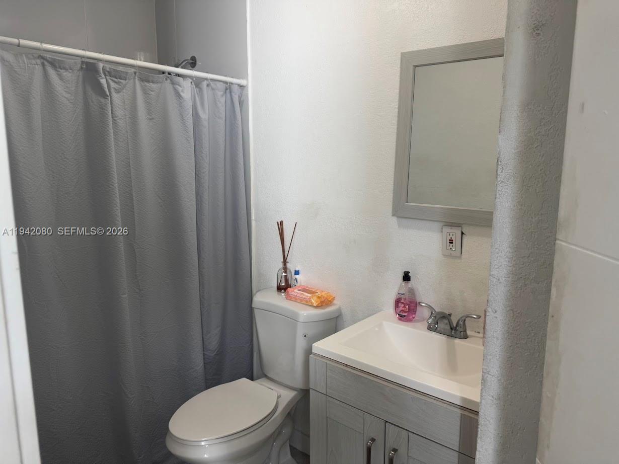 412 West 15th Street Hialeah, FL 33010 - Photo 37 of 48 a bathroom with a sink a toilet and shower curtain