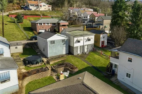 an aerial view of a house with swimming pool and outdoor seating