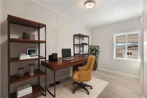 a view of a workspace with furniture and a window