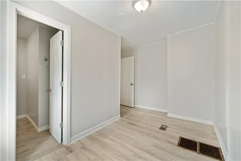 an empty room with wooden floor and closet