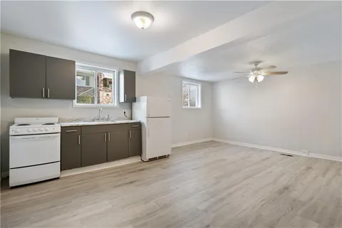 a view of a kitchen with a sink and dishwasher with wooden floor