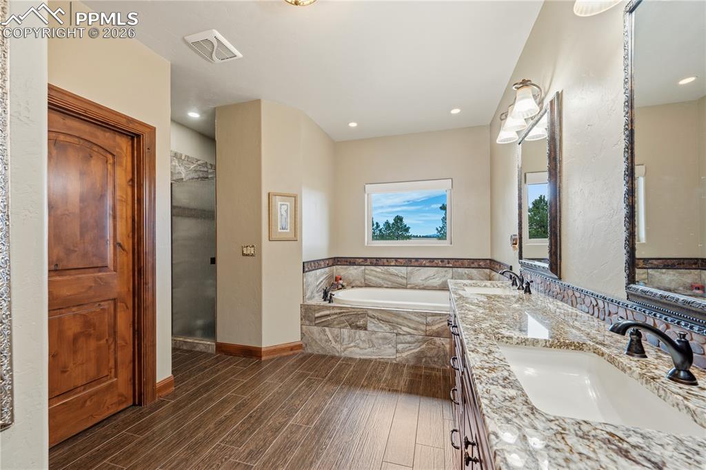 18890 Wing Tip Road Colorado Springs, CO 80908 - Photo 19 of 48 a spacious bathroom with a granite countertop tub sink and mirror
