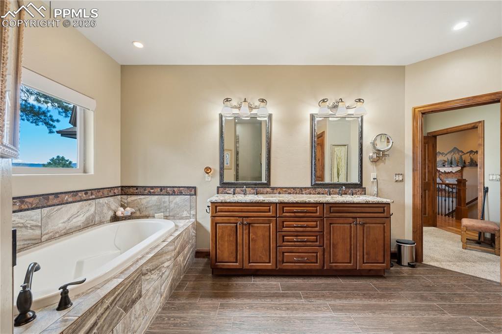 18890 Wing Tip Road Colorado Springs, CO 80908 - Photo 20 of 48 a spacious bathroom with a granite countertop double vanity sink a mirror and a bathtub