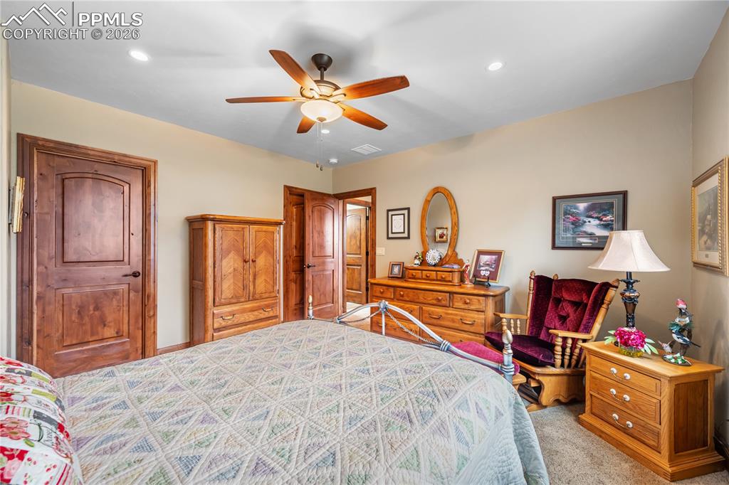 18890 Wing Tip Road Colorado Springs, CO 80908 - Photo 29 of 48 a bedroom with a bed and a chandelier