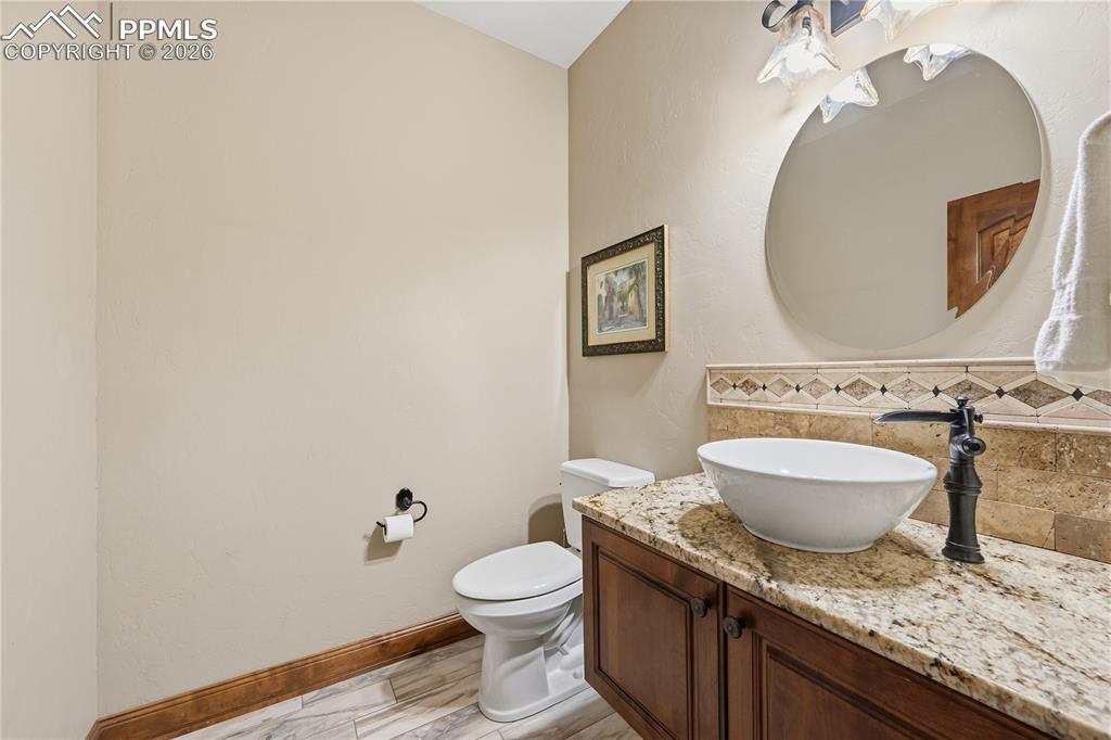 18890 Wing Tip Road Colorado Springs, CO 80908 - Photo 31 of 48 a bathroom with a granite countertop toilet sink and mirror