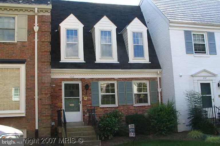 a view of a brick house with windows and yard
