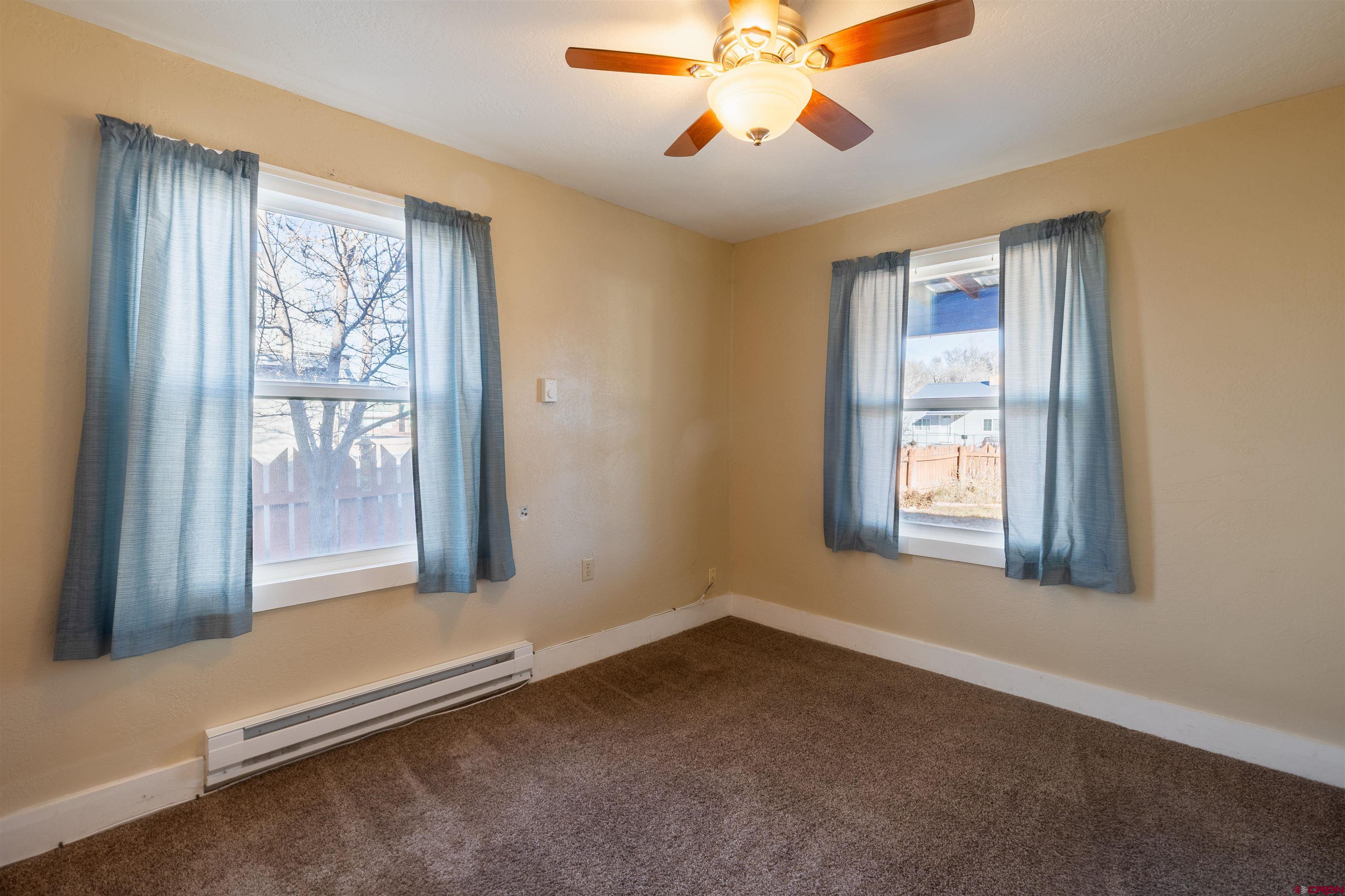 1015 Howard Street Delta, CO 81416 - Photo 10 of 22 an empty room with windows and chandelier fan