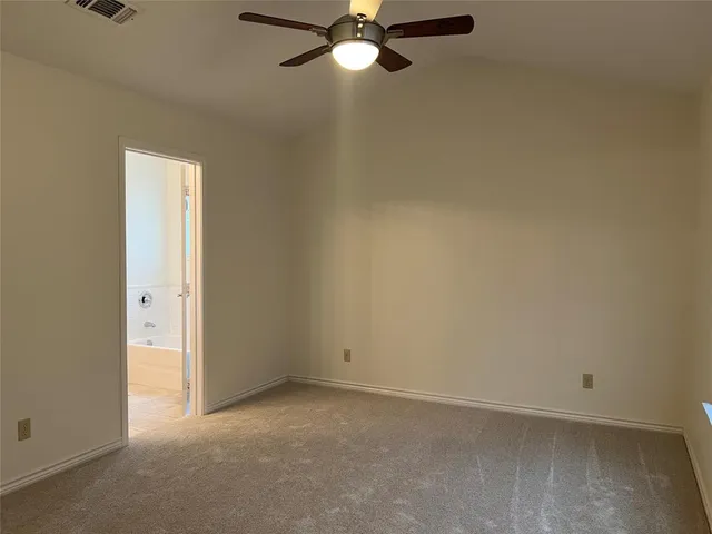 an empty room with a ceiling fan and a window
