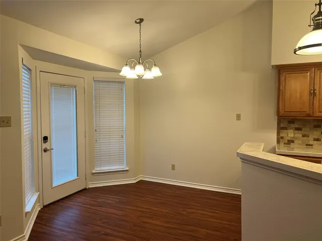 a view of a livingroom with a chandelier wooden floor and chandelier