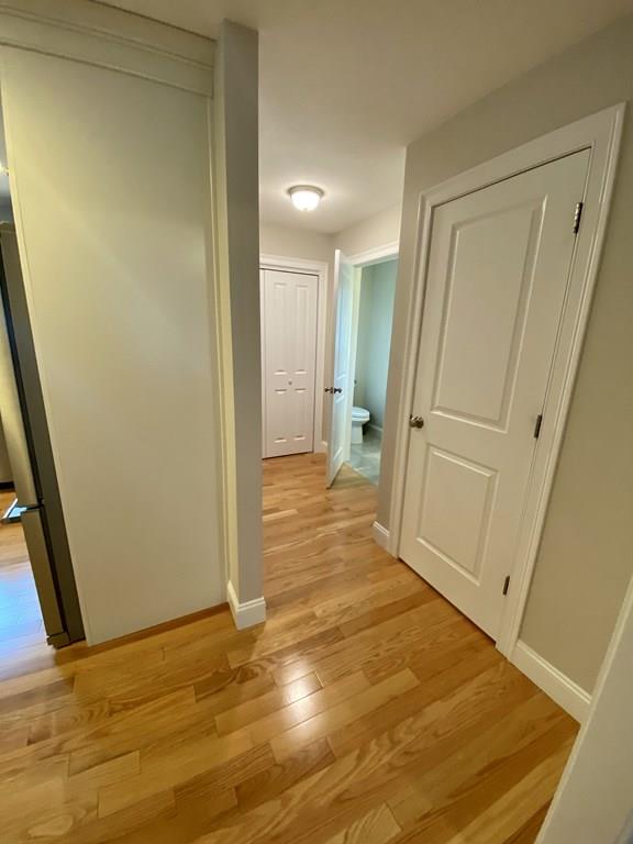 84 Old Pasture Road Dracut, MA 01826 - Photo 10 of 37 a view of a hallway with wooden floor and a bathroom