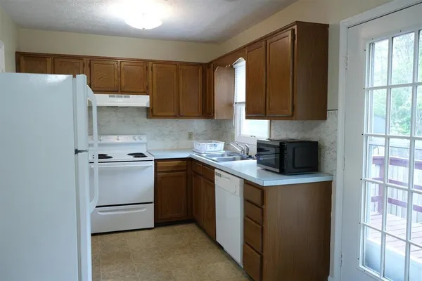 a kitchen with stainless steel appliances granite countertop a refrigerator and a stove