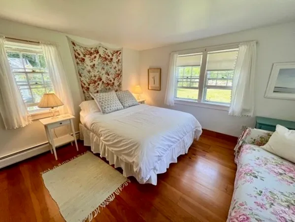 a bedroom with a bed lamps and wooden floor