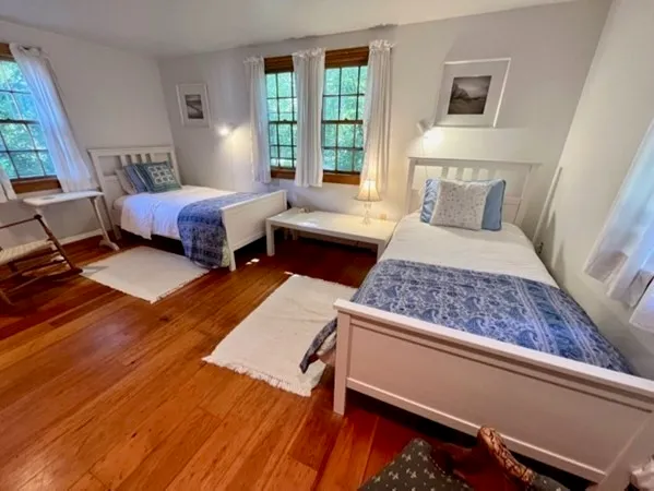 a bedroom with two beds and a large window