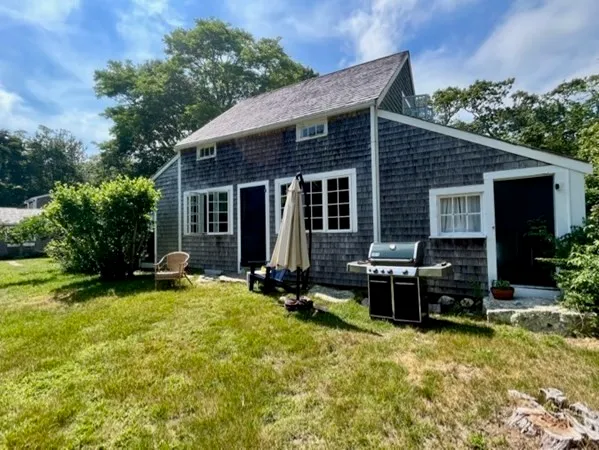 a view of a house with backyard sitting area and garden