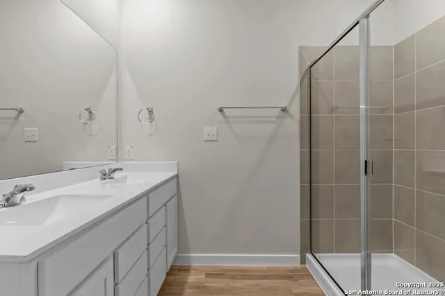 a bathroom with a granite countertop sink a shower and a mirror