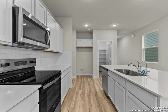 a kitchen with stainless steel appliances granite countertop a sink and a microwave