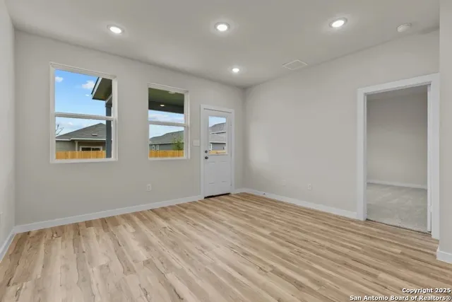 an empty room with windows and fireplace