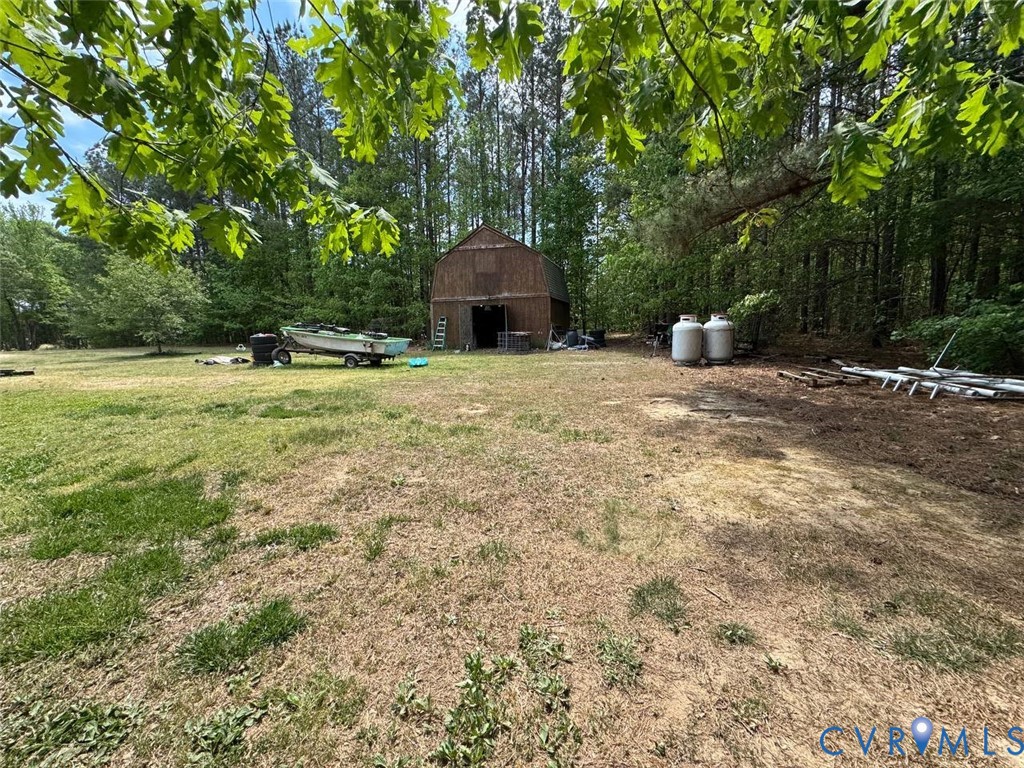 5704 Brills Road McKenney, VA 23872 - Photo 8 of 8 a backyard of a house with table and chairs and wooden fence