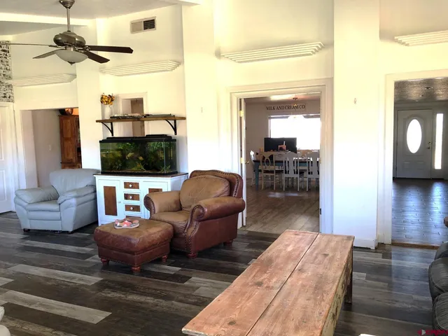 a living room with furniture a flat screen tv and kitchen view