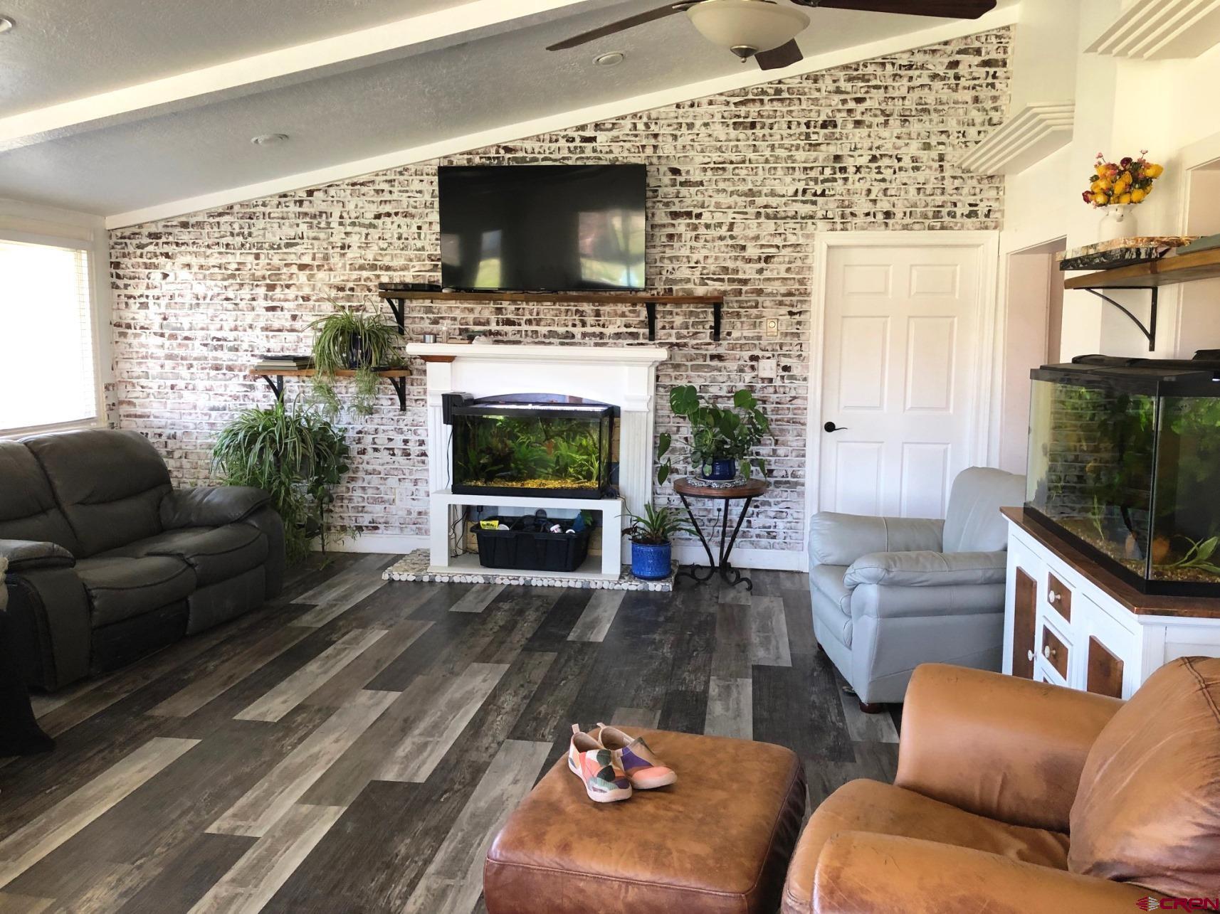 28236 Road H Cortez, CO 81321 - Photo 18 of 37 a living room with furniture a flat screen tv and a fireplace