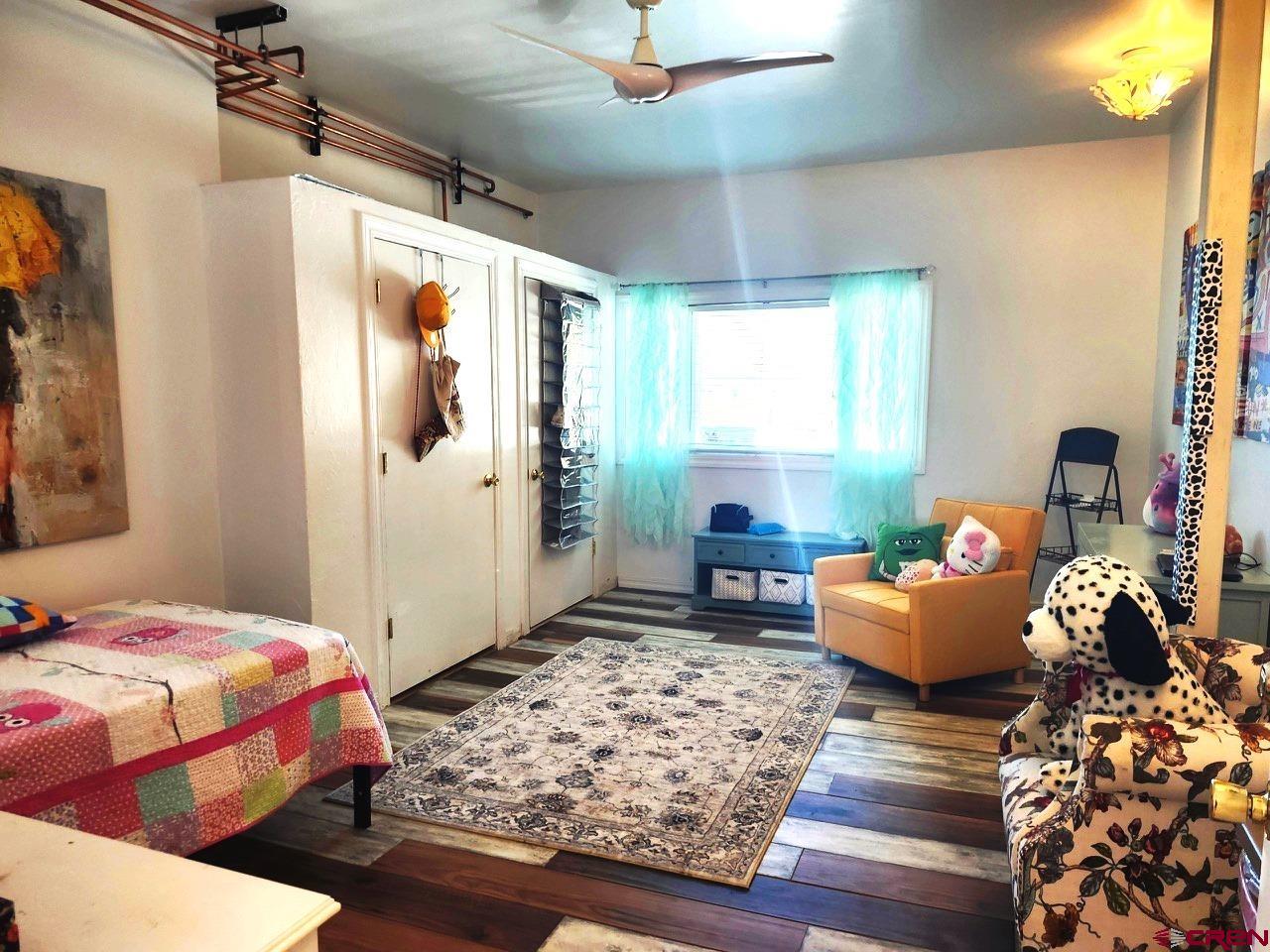 28236 Road H Cortez, CO 81321 - Photo 19 of 37 a bedroom with bed and wooden floor