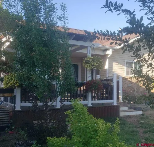 a view of a house with brick walls and a yard with plants