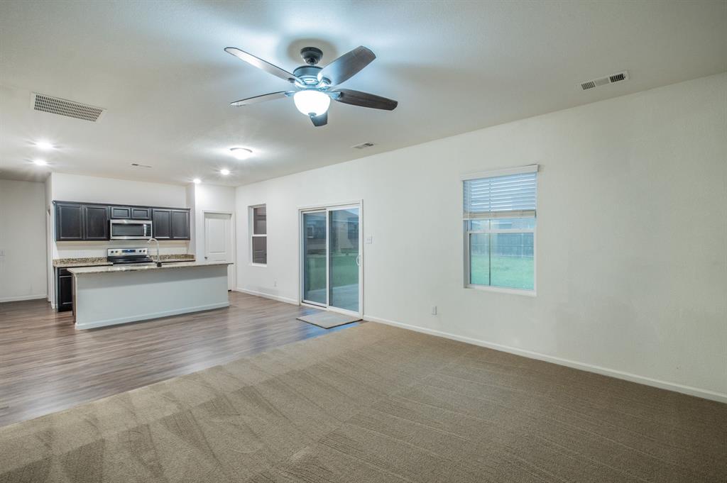 201 Sabine River Road Glenn Heights, TX 75154 - Photo 11 of 24 Open-concept living space featuring a ceiling fan with integrated lighting, recessed lighting, and a sliding glass door providing access to the exterior