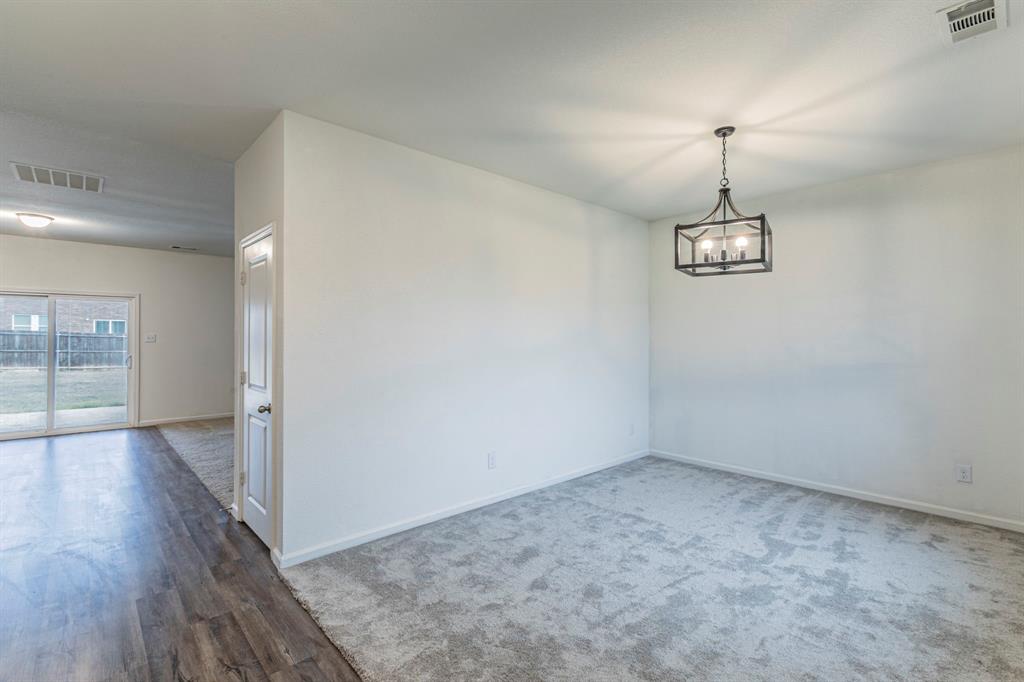 201 Sabine River Road Glenn Heights, TX 75154 - Photo 14 of 26 Unfurnished dining area featuring carpet floors, wood like finished floors, and a chandelier