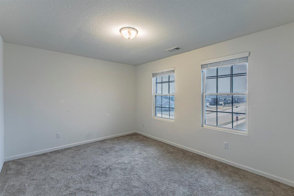 201 Sabine River Road Glenn Heights, TX 75154 - Photo 22 of 26 Carpeted spare room featuring baseboards and a textured ceiling