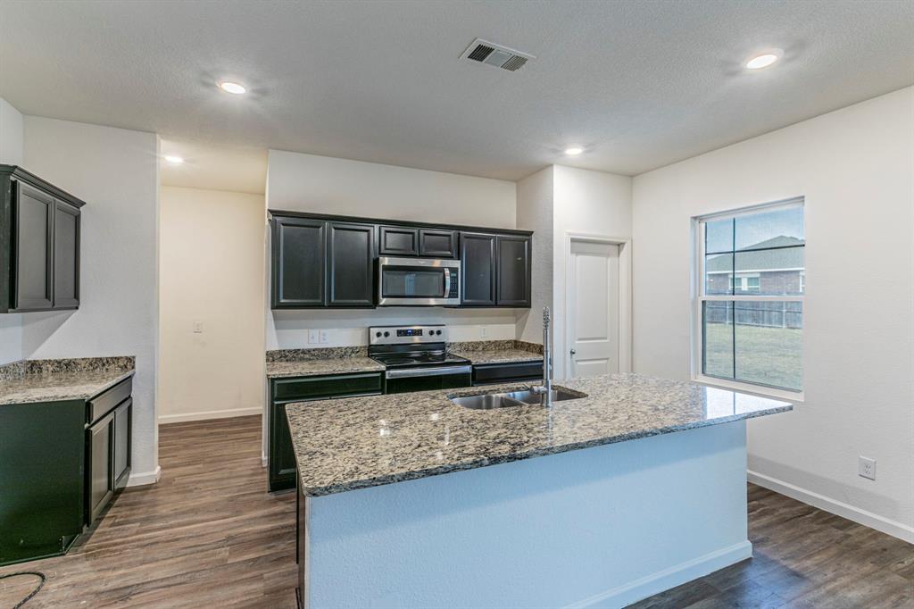 201 Sabine River Road Glenn Heights, TX 75154 - Photo 8 of 24 a kitchen with granite countertop a stove and a sink