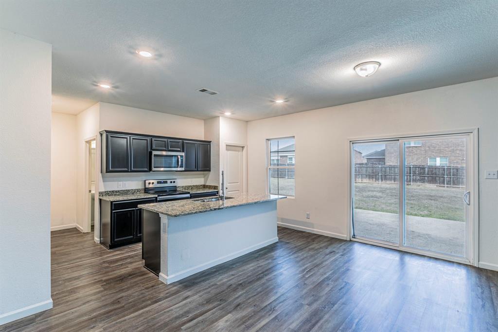 201 Sabine River Road Glenn Heights, TX 75154 - Photo 9 of 24 a kitchen with stainless steel appliances a stove top oven and a refrigerator